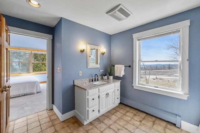 ensuite bathroom featuring a healthy amount of sunlight, a baseboard heating unit, baseboards, and visible vents
