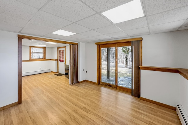 spare room featuring a baseboard heating unit, a paneled ceiling, a baseboard radiator, and baseboards