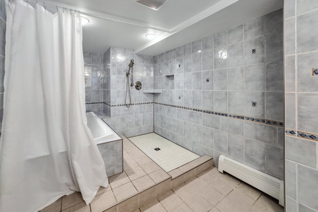 bathroom featuring a tile shower, tiled tub, a baseboard heating unit, tile walls, and tile patterned floors