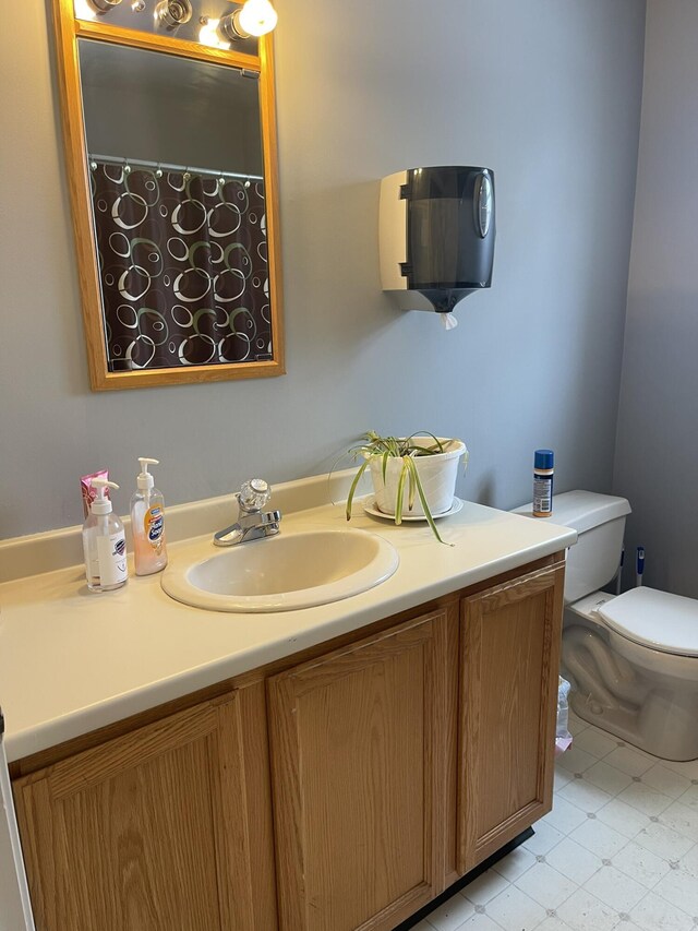 bathroom with tile patterned floors, curtained shower, toilet, and vanity