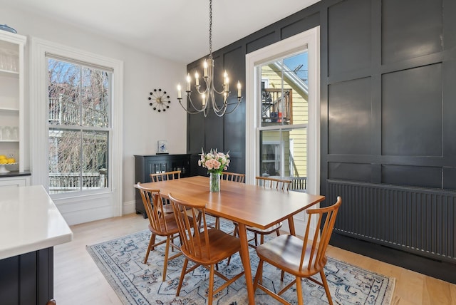 dining space with light wood-style floors and a chandelier