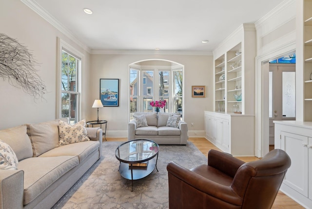 living room featuring light wood-style floors, arched walkways, and ornamental molding