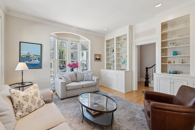 living area with built in features, baseboards, light wood finished floors, ornamental molding, and recessed lighting