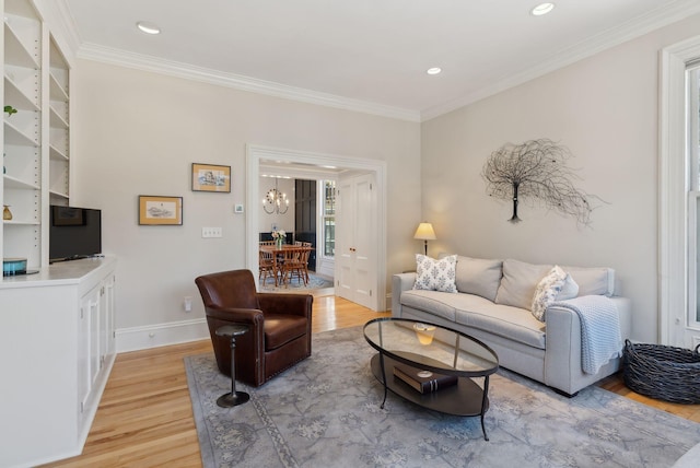 living area featuring crown molding, light wood-type flooring, baseboards, a chandelier, and recessed lighting