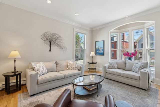 living area featuring crown molding, baseboard heating, light wood-type flooring, baseboards, and recessed lighting