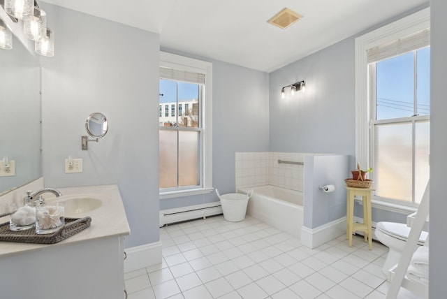 bathroom with baseboards, baseboard heating, and a healthy amount of sunlight
