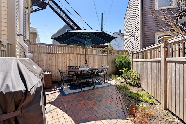 view of patio featuring area for grilling, a fenced backyard, and outdoor dining space