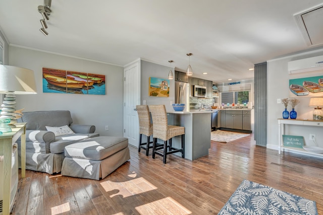 369 Main St Unit 3, Ogunquit, ME 03907 - living room featuring attic access, recessed lighting, a wall unit AC, ornamental molding, and hardwood / wood-style flooring