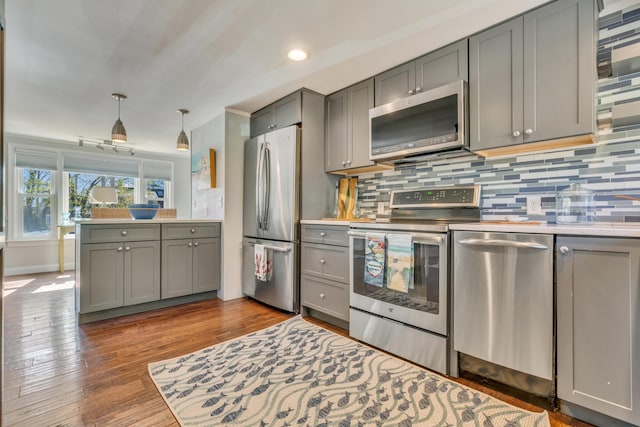 369 Main St Unit 3, Ogunquit, ME 03907 - kitchen with gray cabinets, pendant lighting, appliances with stainless steel finishes, tasteful backsplash, and wood-type flooring