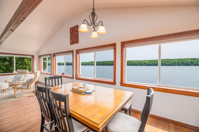 4 Tabert Ln, Belgrade, ME 04917 - dining area featuring lofted ceiling, light wood-style flooring, a chandelier, and a water view