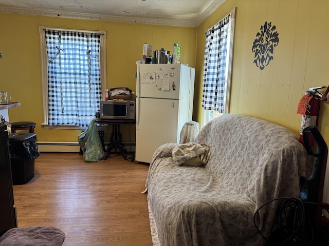 6 Spring St, Waterville, ME 04901 - bedroom featuring freestanding refrigerator, a baseboard heating unit, wood finished floors, and ornamental molding