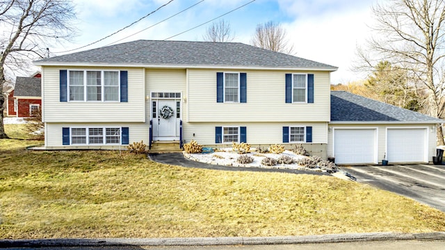 split foyer home featuring a garage, a front lawn, aphalt driveway, a shingled roof, and entry steps