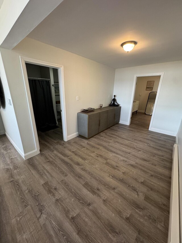 empty room featuring baseboards and dark wood-style floors