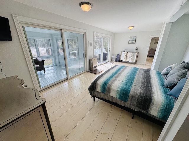 bedroom with access to exterior and light wood-style flooring