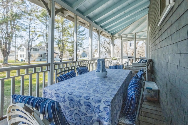 sunroom / solarium with outdoor dining area and a residential view
