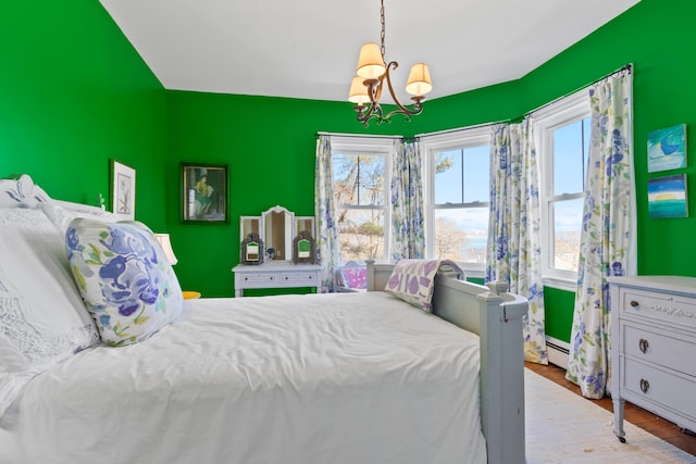 bedroom featuring baseboard heating, a notable chandelier, and wood finished floors