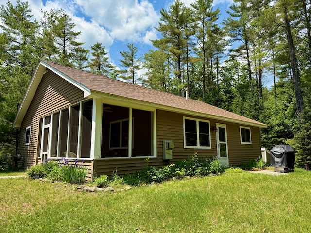52 Main Rd, Chesterville, ME 04938 - view of front facade with a sunroom, a front yard, and a shingled roof