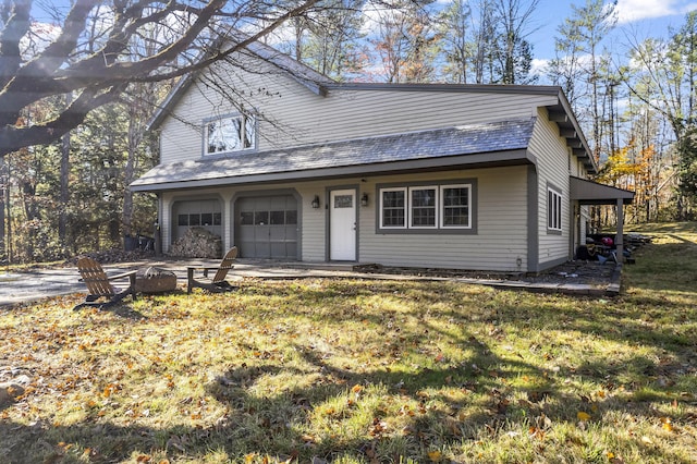 2 Mountain View Ln, Readfield, ME 04355 - view of front facade with a front yard, a fire pit, and an attached garage