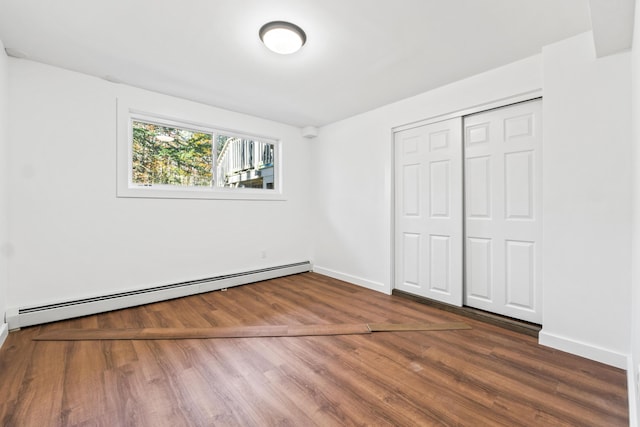 2 Mountain View Ln, Readfield, ME 04355 - unfurnished bedroom featuring a baseboard radiator, baseboards, a closet, and wood finished floors