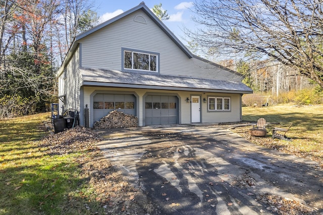 2 Mountain View Ln, Readfield, ME 04355 - view of front of property with an outdoor fire pit, a garage, aphalt driveway, and a front lawn