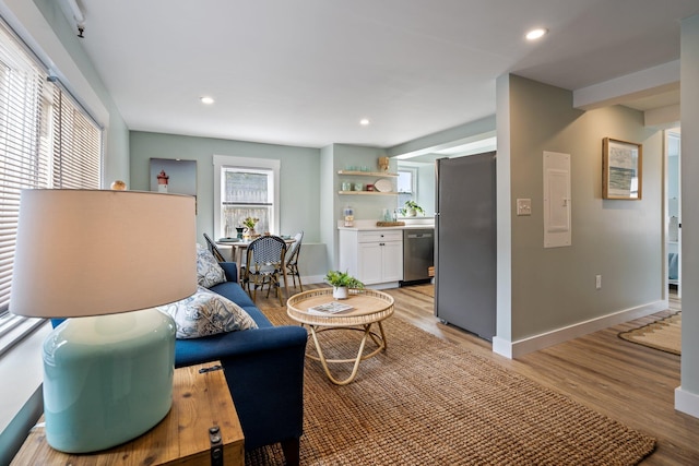 living room featuring light wood-style floors, baseboards, and recessed lighting