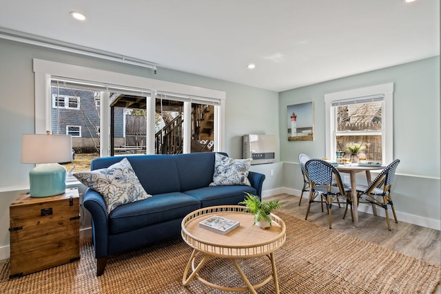living area featuring recessed lighting, baseboards, wood finished floors, and a healthy amount of sunlight