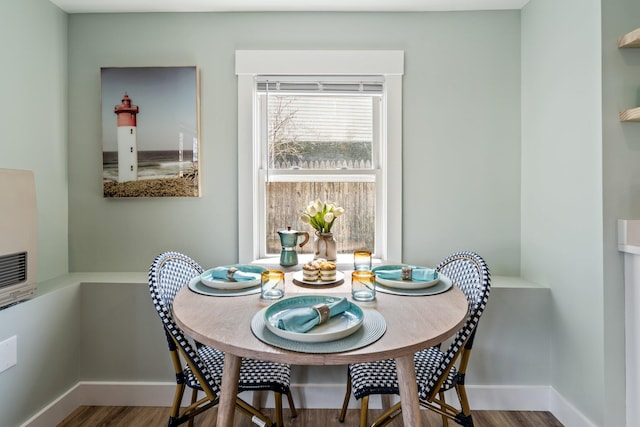 dining area with baseboards and wood finished floors
