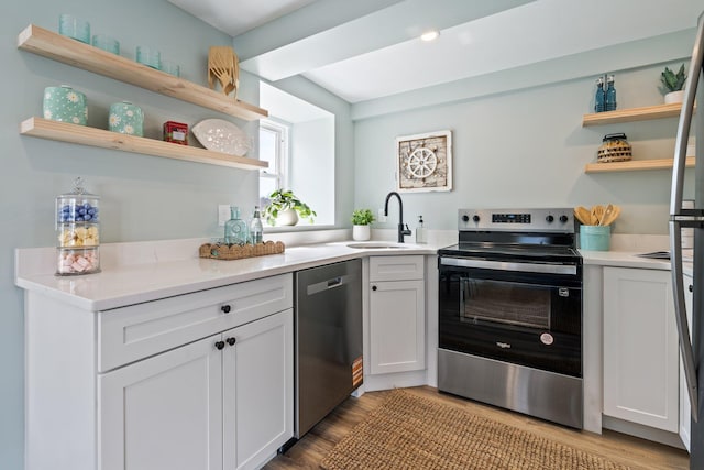 kitchen featuring a sink, light countertops, open shelves, and stainless steel appliances
