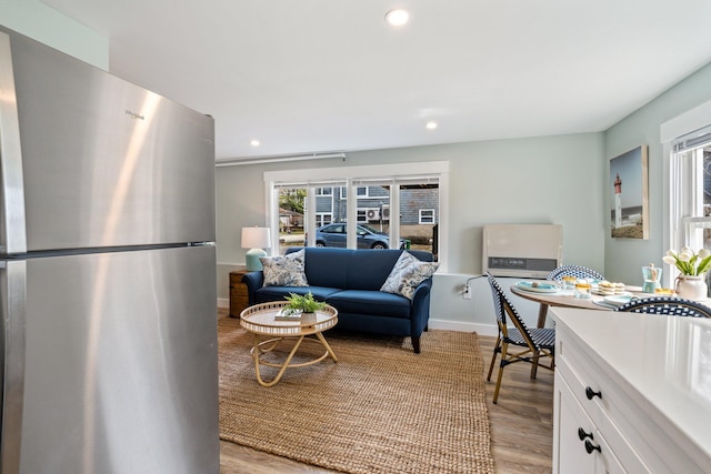 living room with recessed lighting, light wood-style flooring, and baseboards