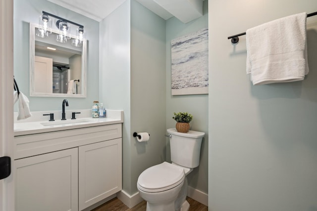 full bathroom with toilet, wood finished floors, vanity, and baseboards