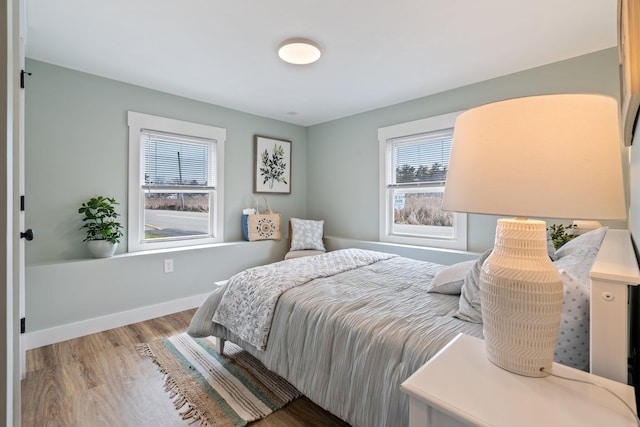 bedroom with baseboards and wood finished floors