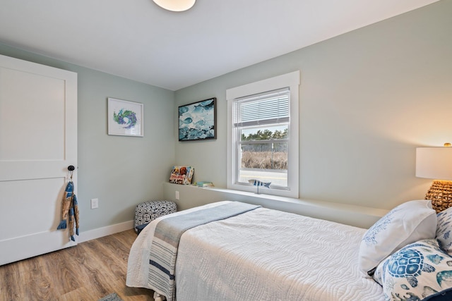 bedroom with baseboards and wood finished floors