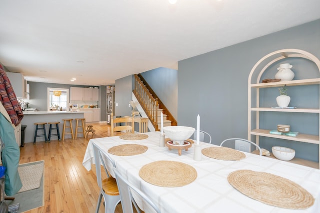 dining space with stairway and light wood-type flooring