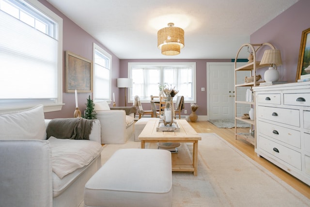living area featuring light wood-style floors and baseboards