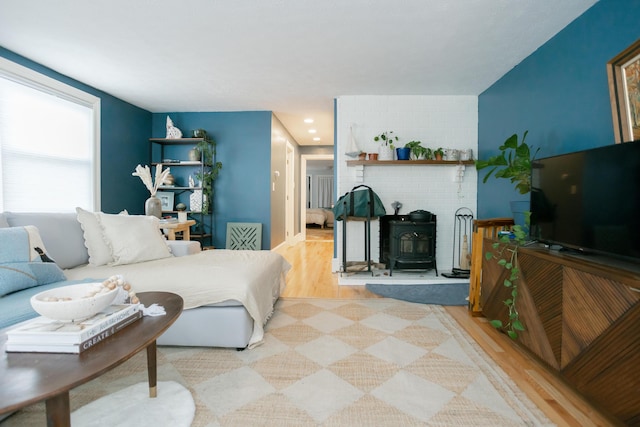 living area with a wood stove, recessed lighting, and wood finished floors