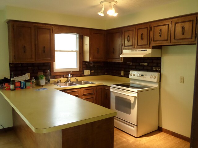 365 Country Club 3rd Rd, Sanford, ME 04073 - kitchen featuring white electric range oven, under cabinet range hood, a sink, a peninsula, and light countertops