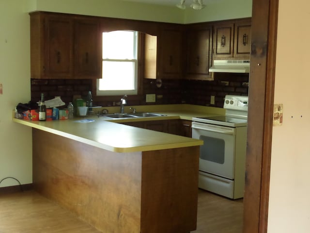 365 Country Club 3rd Rd, Sanford, ME 04073 - kitchen featuring white electric range, under cabinet range hood, a sink, a peninsula, and light countertops