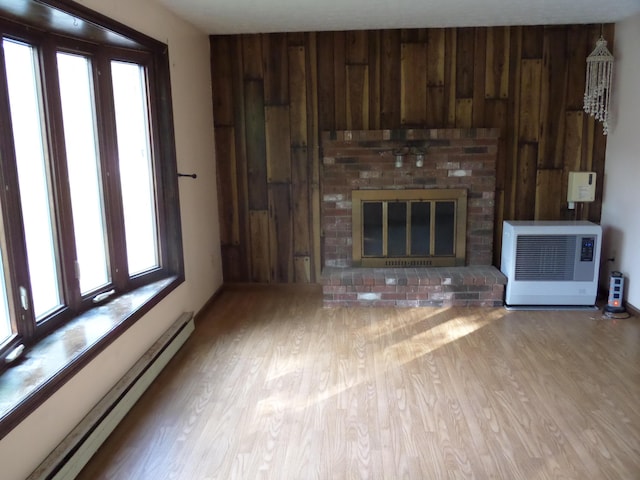 365 Country Club 3rd Rd, Sanford, ME 04073 - unfurnished living room with a baseboard radiator, plenty of natural light, wood finished floors, and wooden walls