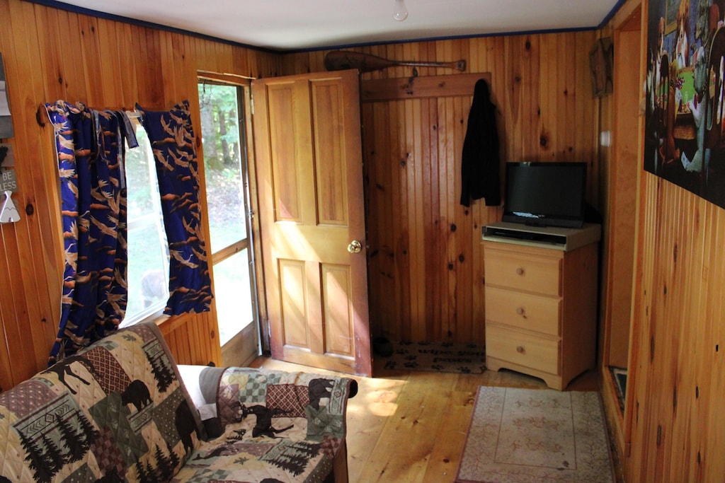 bedroom with light wood-style flooring and wood walls