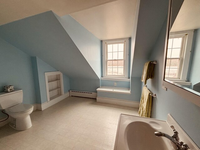 20 Water St, Winterport, ME 04496 - bathroom featuring a baseboard radiator, baseboards, toilet, lofted ceiling, and a sink