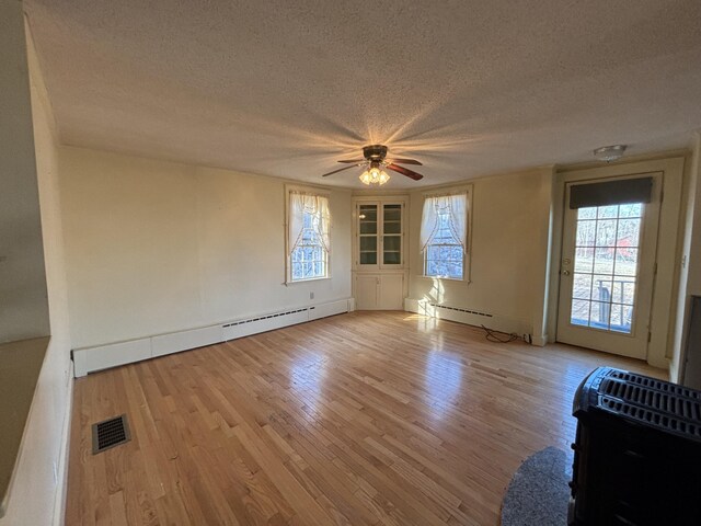20 Water St, Winterport, ME 04496 - spare room with a textured ceiling, ceiling fan, a baseboard heating unit, and light wood-style floors