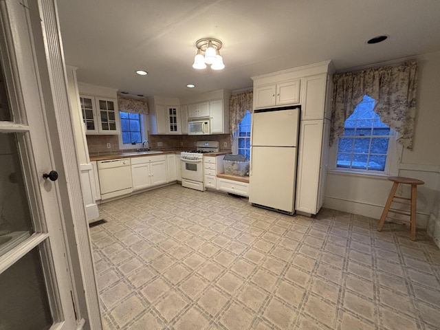 20 Water St, Winterport, ME 04496 - kitchen with white cabinetry, light floors, glass insert cabinets, and white appliances