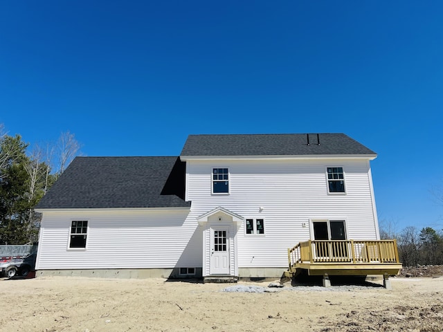 rear view of property with roof with shingles and a deck