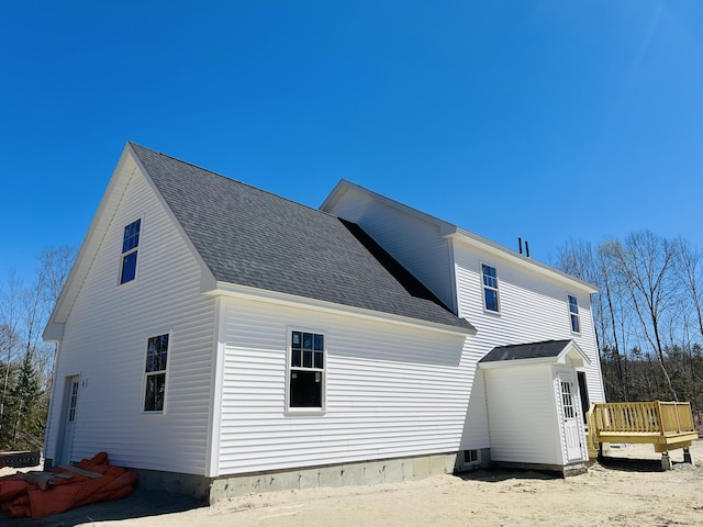 back of property featuring a deck and a shingled roof