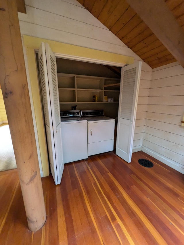 laundry room with wooden walls, laundry area, dark wood finished floors, washer and clothes dryer, and wood ceiling
