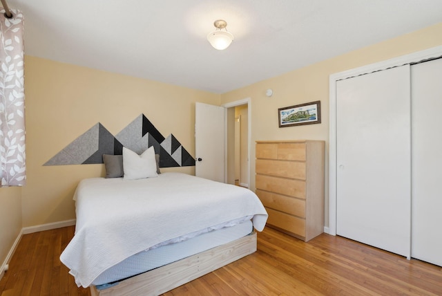 bedroom featuring baseboards, a closet, and light wood-style flooring