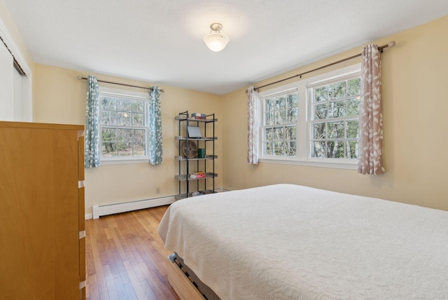 bedroom featuring wood-type flooring and a baseboard radiator