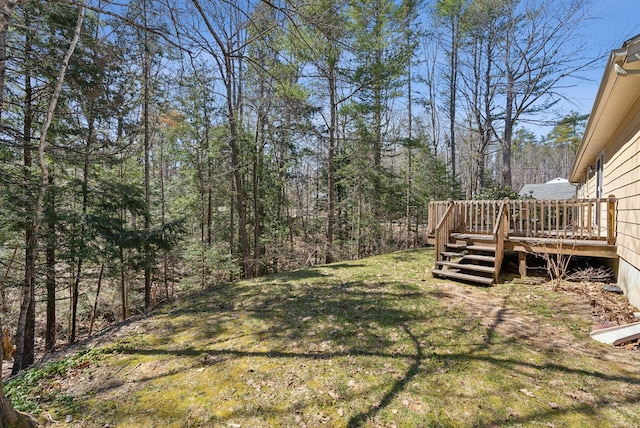 view of yard with a wooden deck and a forest view