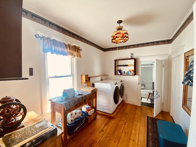 laundry area with washer and clothes dryer, crown molding, laundry area, and light wood-type flooring