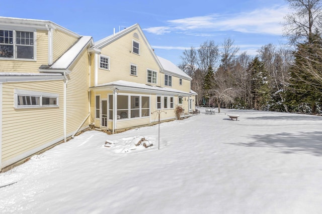 snow covered property featuring a sunroom